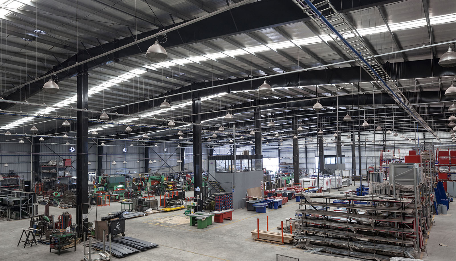 Foto interior espacio de producción de fábrica, grandes luces, estructura metálica